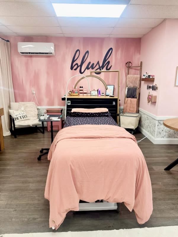 The treatment room: soft pink walls, warm light, and the table made up and waiting.